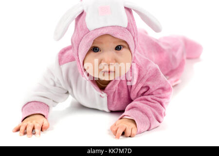 Ritratto di quattro month bambino età di quattro month che giace sul pavimento indossando coniglietto vestito isolato su bianco Foto Stock