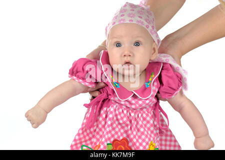 Adorabili babygirl indossando rosa chiude sostenuto da madre le mani isolato su bianco Foto Stock