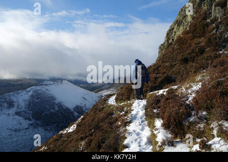 Lone fellwaker maschio su un percorso sotto la cima dirupi del wainwright causey pike nel parco nazionale del distretto dei laghi, cumbria.uk. Foto Stock