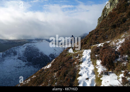 Lone fellwaker maschio su un percorso sotto la cima dirupi del wainwright causey pike nel parco nazionale del distretto dei laghi, cumbria.uk. Foto Stock