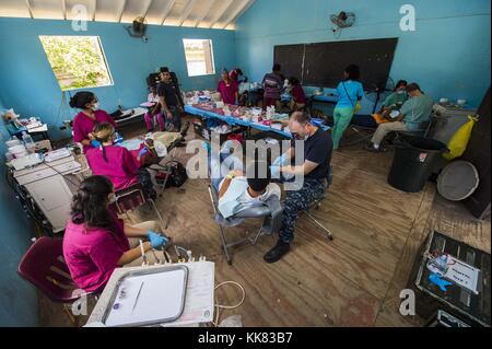 Marinai e organizzazione non governativa volontari assegnati ai militari di comando Sealift nave ospedale USNS Comfort T-AH 20 eseguire procedure dentali su pazienti in un sito medico istituito presso la Dominica Grammar School a sostegno della promessa continua 2015, Roseau, Dominica. Immagine cortesia la comunicazione di massa specialista in seconda classe Derek Paumen/US Navy, 2015. Foto Stock