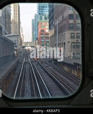 L brani in Chicago Downtown Loop sono incorniciate al di fuori della finestra dell'ultima vettura su una linea marrone treno che attraversa il fiume. Foto Stock