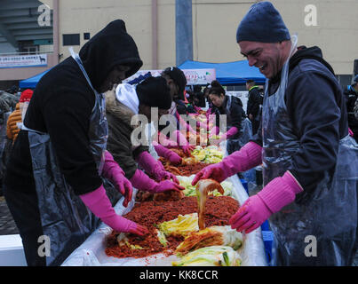 Soldati assegnato al campo 210th brigata di artiglieria, seconda divisione di fanteria/ROK-US Divisione combinata e 125th meccanizzata del battaglione di fanteria, Repubblica di Corea 26 dell esercito meccanizzato di divisione di fanteria partecipare nel 2017 Dongducheon Centro di volontariato Kimchi annuale evento di beneficenza con persone provenienti da comunità locali organizzazioni a Dongducheon multi stadio complessa, Dongducheon, Repubblica di Corea, nov. 22, 2017. Alla manifestazione hanno fatto Kimchi e li ha distribuiti quelli della comunità locale che erano nel bisogno. (U.S. Esercito Foto di Sgt. Michelle U. Blesam, 210th FA Bde Affari pubblici) Foto Stock