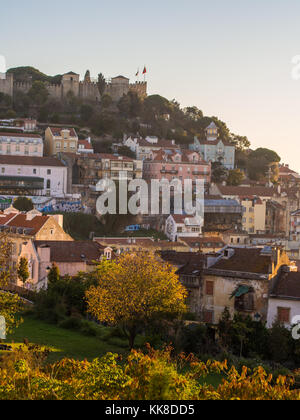 La soa jorge castle a Lisbona, Portogallo, con le case introno architettura, al tramonto. Foto Stock