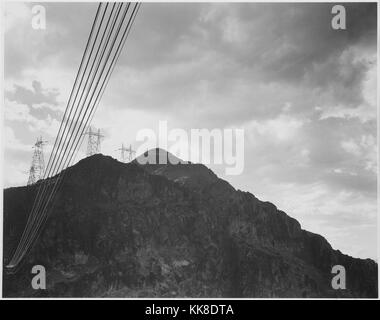 Fotografia in bianco e nero guardando verso la montagna con la Diga di Boulder, ora la Diga di Hoover, linee di trasmissione sul picco e close-up di fili, di Ansel Adams, 1942. Immagine cortesia archivi nazionali. Foto Stock