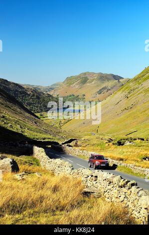 Passo di Kirkstone, Cumbria, Inghilterra. Il traffico sale al passo Kirkstone da Brotherswater, Patterdale in lontananza verso Ambleside Foto Stock