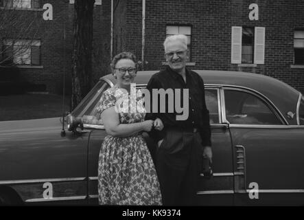 In volgare fotografia istantanea di coppia felice e antichi auto, 1963. Foto Stock