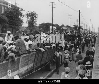 Fotografia in bianco e nero di un grande gruppo di cotone hoers caricamento in carri scoperti a Memphis per il lavoro del giorno in Arkansas, Giugno 1937. Dalla Biblioteca Pubblica di New York. Foto Stock