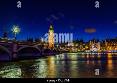 Un famoso punto di riferimento, la torre dell'orologio del Big ben di notte, presa dal lato sud del Tamigi nel centro di Londra. Foto Stock