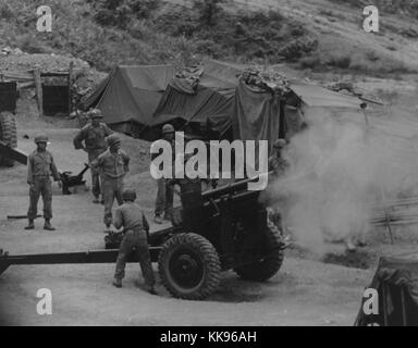 Fotografia in bianco e nero di un gruppo di artiglieri vietnamita sparare da una posizione di montagna durante la formazione sul campo, tende in background, 1962. Dalla Biblioteca Pubblica di New York. Foto Stock