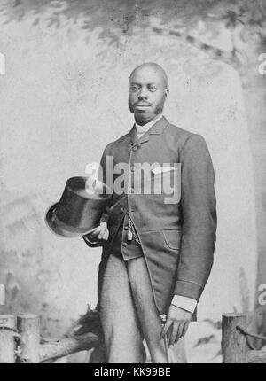 Seppia studio ritratto di un uomo afro-americana, indossa una tuta e tenendo un top hat e un bastone, 1900. Dalla Biblioteca Pubblica di New York. Foto Stock