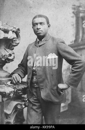 Seppia studio ritratto di una giovane uomo afro-americano, tre quarti di lunghezza, in un vestito, 1900. Dalla Biblioteca Pubblica di New York. Foto Stock