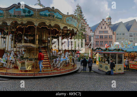 Francoforte, Germania. 28 Nov 2017. Passers-by guarda un carosello per bambini vecchio stile sulla piazza centrale Römerberg con il municipio medievale (Römer) sullo sfondo. Come uno dei più antichi mercatini di Natale in Germania, il mercatino di Natale di Francoforte si tiene ogni anno al tempo dell'Avvento. E' inoltre, con circa 3 milioni di visitatori, uno dei più grandi mercatini di Natale della Germania. Credit: Michael Debets/Pacific Press/Alamy Live News Foto Stock