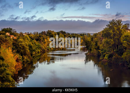 Guardando attraverso il Tarn Fiume in lisle sur tarn sotto i cieli blu wirh nubi sparse, midi-Pyrenees, Francia Foto Stock