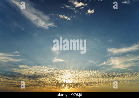 Ora d'oro raggi del sole attraverso il bellissimo basso bianco nubi sparse su orange blue sky, istanbul, Turchia Foto Stock