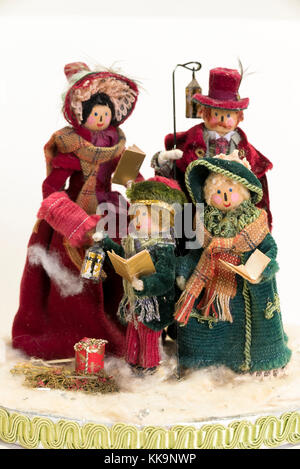 Una festa di natale decorazione realizzata con picchetti di legno e un assortimento di stoffe colorate che rappresentano una famiglia di quattro canti di canto di Natale Foto Stock