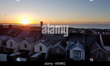 Di brina sui tetti delle case di Mount Pleasant inizia lo scongelamento come il sole sorge sulla Baia di Swansea. Mercoledì 29 Novembre 2017 Foto Stock