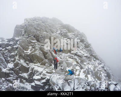 Scomposizione del gruppo / passeggiate nel paesaggio invernale, Tryfan, Ogwen Valley, Snowdonia, Wales, Regno Unito Foto Stock