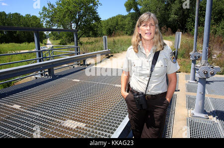 Muscatine, Iowa, Stati Uniti. 8 agosto 2017. In cima a una struttura di controllo delle acque Port Louisa National Wildlife Refuge Manager Sally Flatland parla di come la gestione delle acque sia una delle maggiori sfide per la gestione del rifugio. Gli obiettivi principali del rifugio sono conservare e migliorare la qualità e la diversità dei pesci e della fauna selvatica e dei loro habitat; e ripristinare le funzioni delle pianure alluvionali nel corridoio fluviale. Credit: Kevin E. Schmidt/Quad-City Times/ZUMA Wire/Alamy Live News Foto Stock