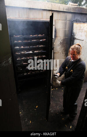 Harpers Ferry, Iowa, Stati Uniti. 29 Agosto 2017. Vickie Jones BEGIN chiude una porta su un lato di un grande fumatore dove le sezioni di pesce rimarranno per almeno 8 ore al mercato del pesce di Mohn vicino a Harpers Ferry Iowa. Credit: Kevin E. Schmidt/Quad-City Times/ZUMA Wire/Alamy Live News Foto Stock