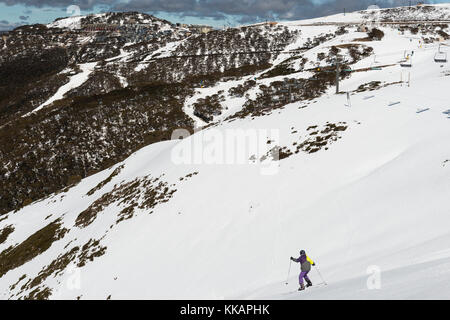 Sci da giovane lungo lo scivolo e Mount Hotham Village, Mount Hotham, Victoria, Australia, Pacifico Foto Stock