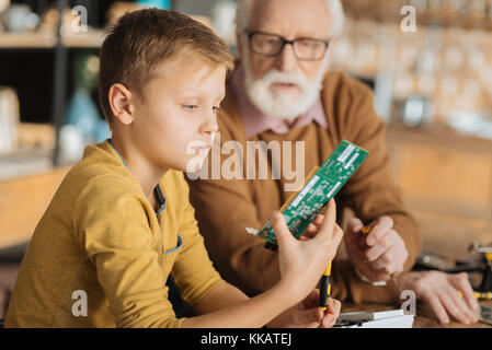 Grave ragazzo intelligente di imparare a risolvere le cose Foto Stock