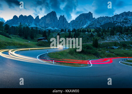 Auto trail luci sul Passo Pordoi con sfondo di montagne al tramonto, Provincia Autonoma di Bolzano Alto Adige, Dolomiti italiane, Italia, Europa Foto Stock