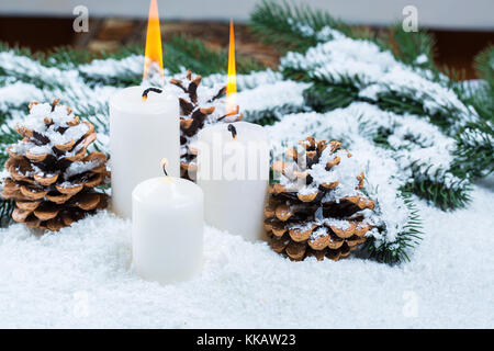 Natale e Anno Nuovo sfondo con candela di Natale e albero di Natale rami sulla neve e decorazioni. Spazio libero Foto Stock