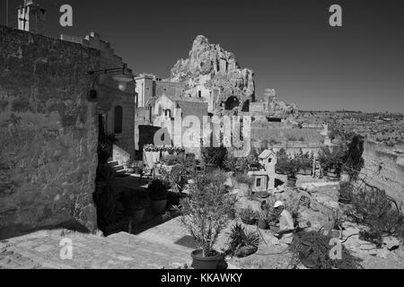 Una casa e giardino cortile sul Rione Malve, Sasso Caveoso, con coniche gobba di Monte Errone oltre, Matera, Basilicata versione in bianco e nero Foto Stock