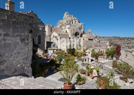 Una casa e giardino cortile sul Rione Malve, Sasso Caveoso, con la protuberanza conica del Monte Errone oltre, Matera, Basilicata, Italia Foto Stock