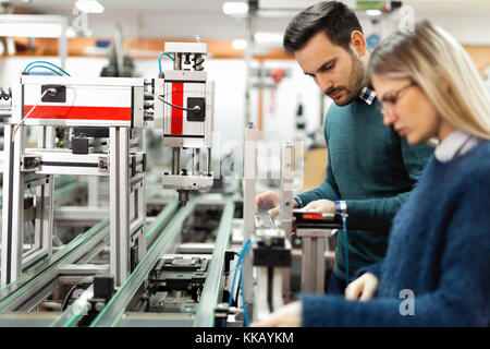 Giovani studenti attraenti della meccatronica lavorando sul progetto Foto Stock