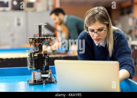 Giovane donna ingegnere di lavoro sul progetto di robotica Foto Stock