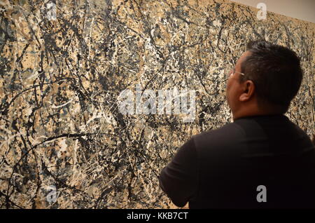 Uomo che guarda al Jackson Pollock del dipinto, 'uno: numero 31, 1950" presso il Museo di Arte Moderna di New York City. Foto Stock