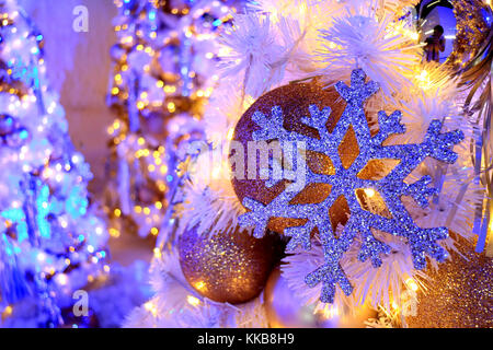 Il simbolo del fiocco di neve glitter glitter e ornamenti a sfera sulla luce-fino ad albero di natale, il fuoco selettivo e sfocate con sfondo bokeh di fondo Foto Stock
