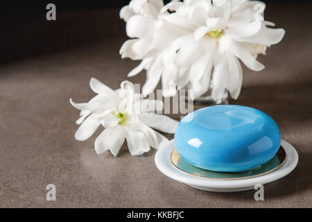 Mousse di moda la torta con una glassa a specchio decorato con fiori di primavera. sfondo scuro. Foto Stock
