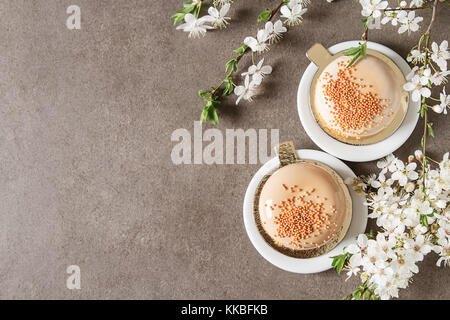 Mousse di moda la torta con una glassa a specchio decorato con fiori di primavera. sfondo scuro. Foto Stock