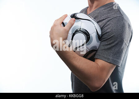 L'uomo tenendo palla calcio close-up isolati su sfondo bianco Foto Stock