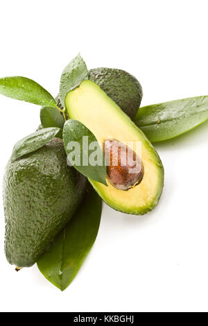Foto di intagliate frutto di avocado con foglie di colore verde su bianco sfondo isolato Foto Stock
