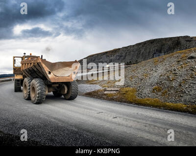 Grande giallo Moxy Carrello guidando attraverso un robusto montuoso valley road. Foto Stock
