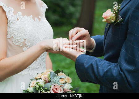 Lo sposo mette l'anello sulla sposa la mano. Ingrandimento di foto Foto Stock