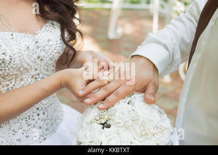 Lo sposo mette l'anello sulla sposa la mano. Ingrandimento di foto Foto Stock