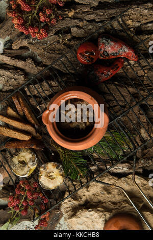 Piatto vegetariano in una pentola di creta con arrosti di verdure alla griglia su uno sfondo di corteccia di albero Foto Stock