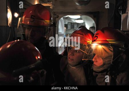 I marinai assegnati al cacciatorpediniere missilistico guidato classe Arleigh Burke USS McCampbell DDG 85 valutano i danni simulati durante un'esercitazione di controllo dei danni, nel Mare della Cina orientale. Per gentile concessione di Seaman Declan Barnes/US Navy, specialista della comunicazione di massa. 2012. Foto Stock