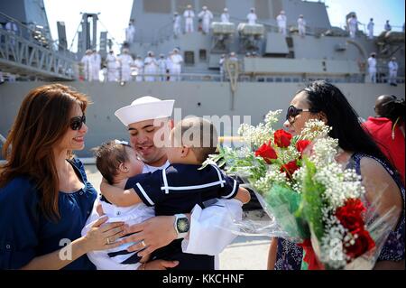 Il Serviceman della nave di terza classe Robert Gomez, assegnato al cacciatorpediniere missilistico guidato della classe Arleigh Burke, il Sullivans DDG 68, vede sua figlia neonata per la prima volta durante una celebrazione del ritorno a casa alla Naval Station Mayport, Mayport, Florida. Immagine gentilmente concessa da Mass Communication Specialist Seaman Apprentice Damian Berg/US Navy. 2012. Foto Stock