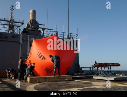 I marinai gonfiano il "pomodoro assassino" sul ponte di volo della fregata missilistica guidata classe Oliver Hazard Perry USS Underwood FFG 36 prima di lanciarlo in acqua prima di iniziare esercitazioni di fuoco vivo, nell'Oceano Pacifico. Immagine gentilmente concessa da Stuart Phillips/US Navy, specialista comunicazioni di massa di seconda classe. 2012. Foto Stock