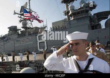 Marinai e marines rendere un omaggio a mano come il multi-purpose Amphibious Assault nave USS makin island lhd 8 passa la USS Arizona Memorial, Pearl harbor, 2012. Immagine cortesia la comunicazione di massa specialista in seconda classe dominique pineiro/us navy. Foto Stock