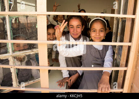 Studenti iracheni posano per una foto attraverso una finestra di scuola in una scuola primaria, Aski Mosul, Iraq, nov. 13, 2017. L ampiezza e la diversità dei partner della coalizione dimostra il livello globale e unified obiettivo di sconfiggere ISIS in Iraq e la Siria. Combined Joint Task Force - Funzionamento inerenti risolvere è la coalizione globale per sconfiggere ISIS in Iraq e la Siria. (U.S. Esercito foto di Sgt. Tracy McKithern) Foto Stock