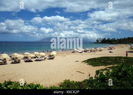 Il Wailea Beach in una giornata di sole con i turisti il ricovero sotto ombrelloni, snorkeling, e utilizzo di stand up paddle boards, Puu Kukui mountain visibile in background, Wailea, Maui, Hawaii, 2016. Foto Stock