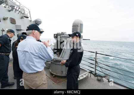 Golfo Arabico (nov. 23, 2017) segretario della Marina Richard V. Spencer parla di artigliare il compagno di classe 1a Benjamin Schreiner, assegnato all'Arleigh Burke-class guidato-missile destroyer USS tramoggia (DDG 70), durante un tour della nave il giorno del Ringraziamento. La tramoggia è distribuito negli Stati Uniti Quinta Flotta area di operazioni a sostegno della sicurezza marittima operazioni per rassicurare gli alleati e partner e preservare la libertà di navigazione e il libero flusso di commercio nella regione. (U.S. Navy foto di Fire Controlman 2a classe Jonathan Clegg/rilasciato) Foto Stock