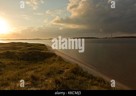 Nc00976-00...North Carolina - sunrise su una mattina nuvoloso con una vista di Cape Lookout stazione di luce da shackleford isola di Cape Lookout National s Foto Stock